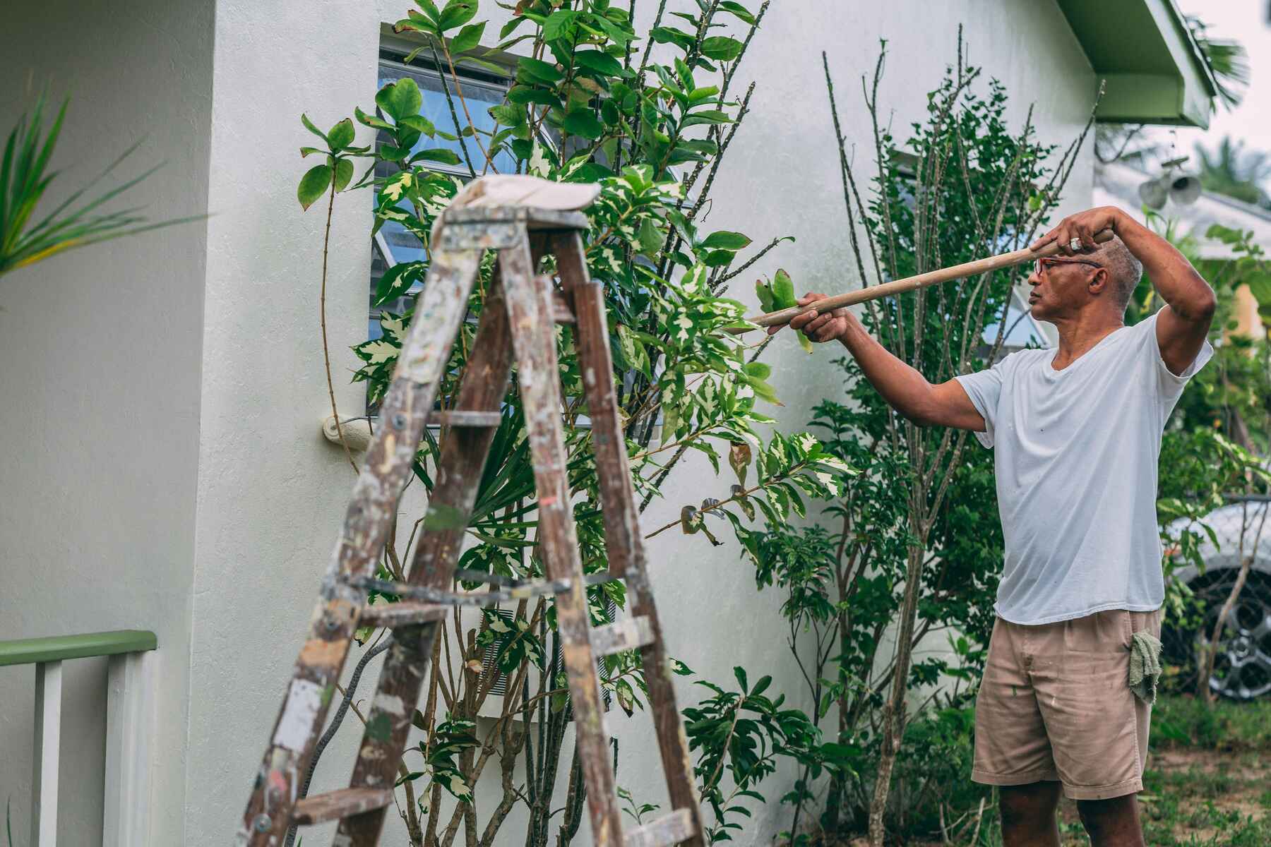 Hombre pintando la pared exterior de una casa