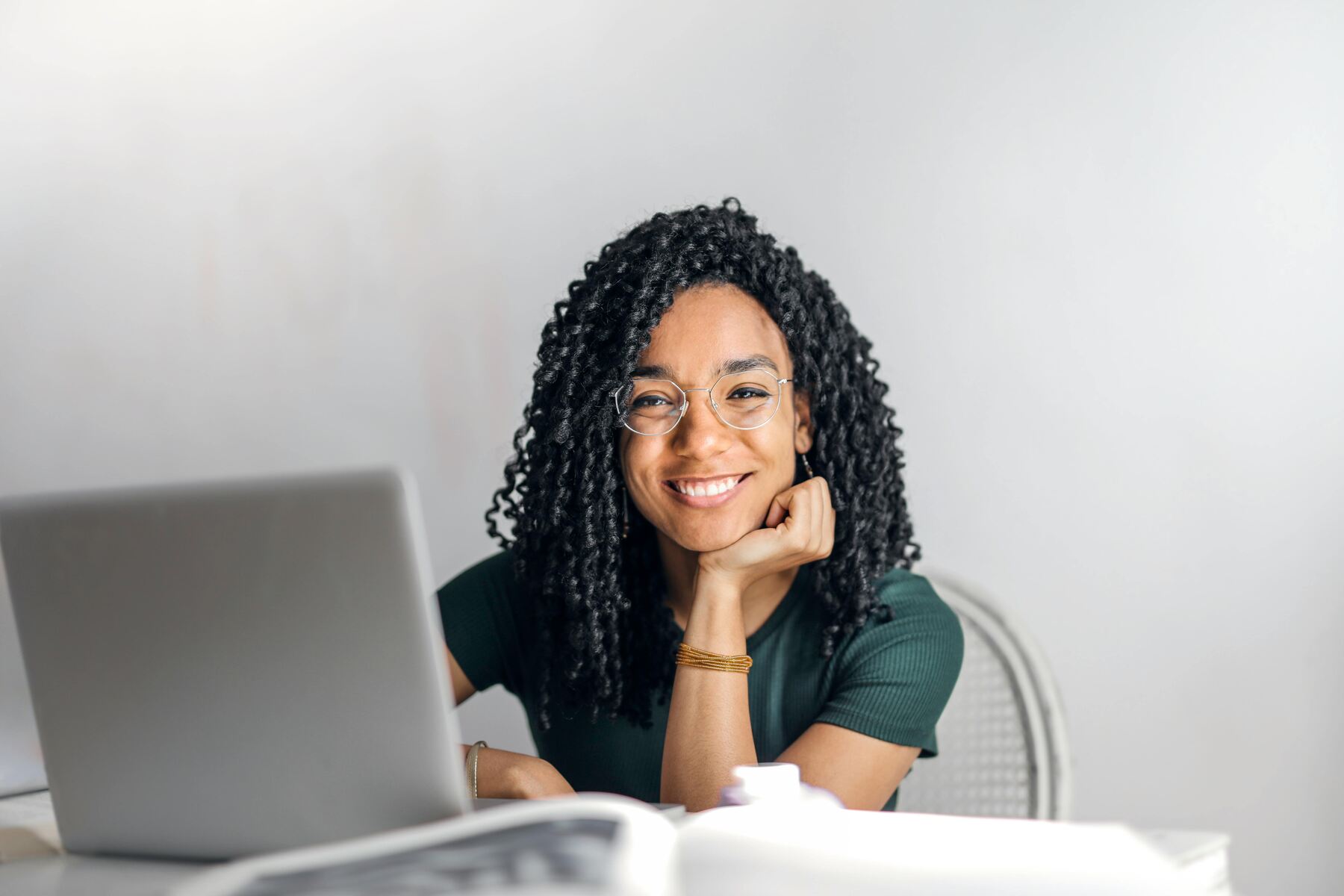 Una mujer sonriente trabajando en marketing digital desde su ordenador portátil