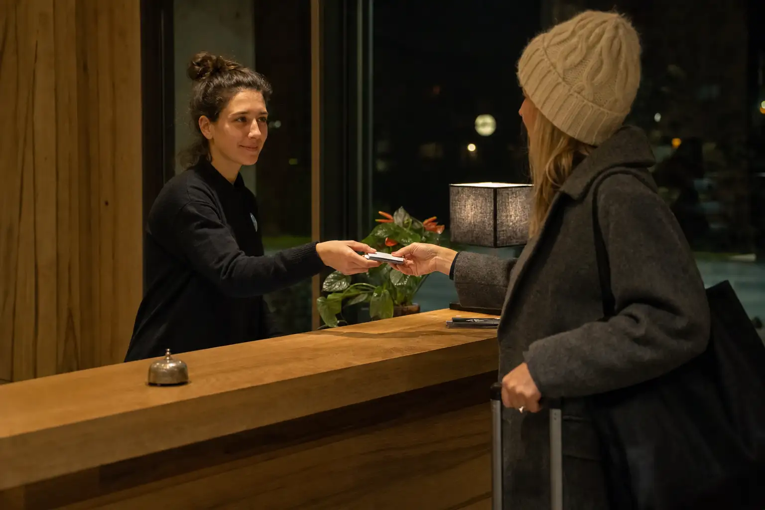 Empleado de hotel gestionando una llegada tardía con acceso preparado en la entrada.